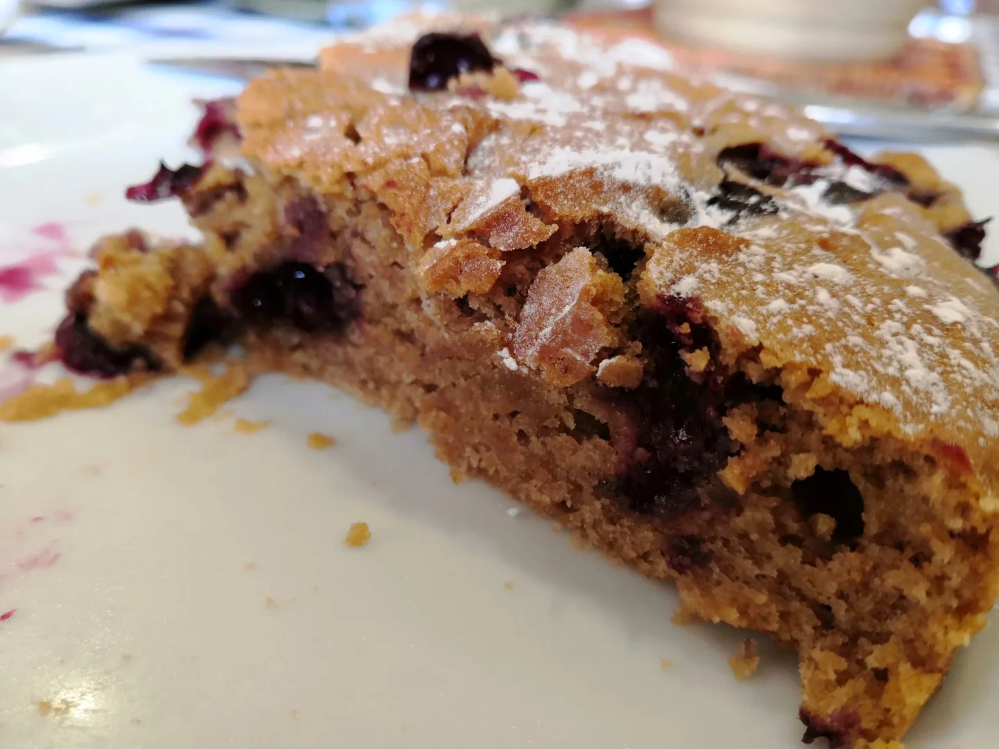 Slice of blueberry cake dusted with icing sugar